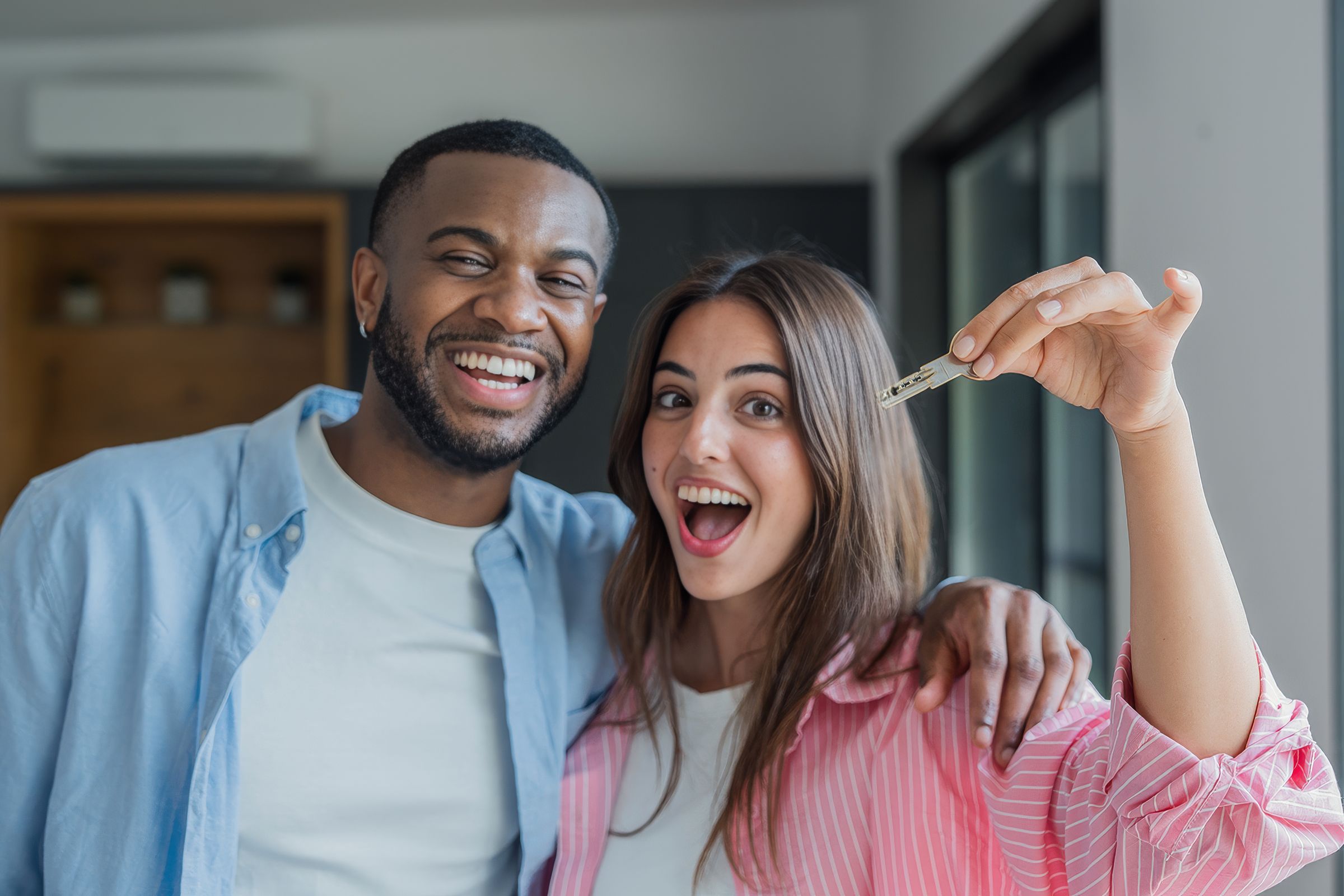 Couple holding keys to their new house on completion day, 14 weeks after having their offer accepted