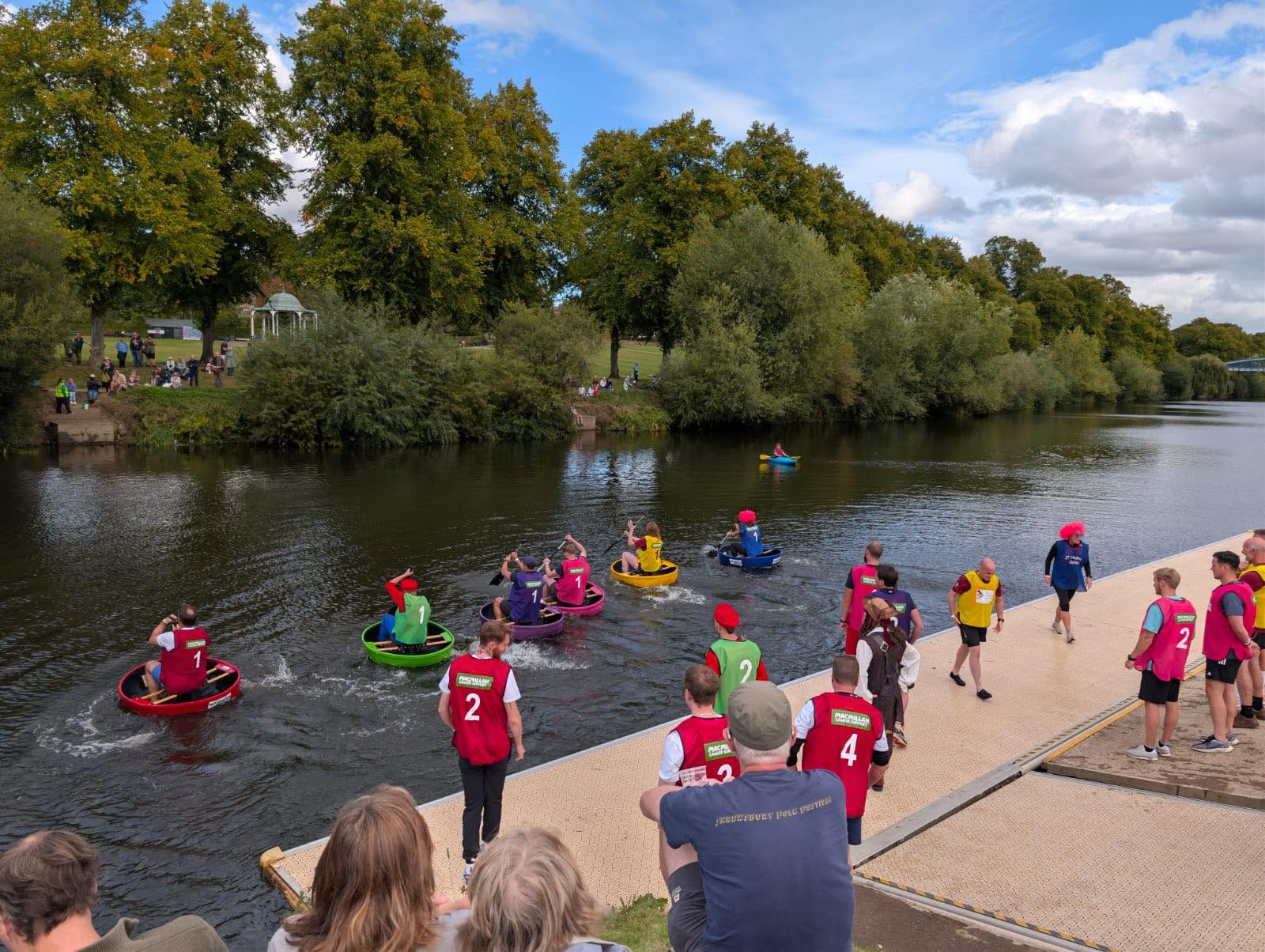 Teams racing across the river in Coracles during the Coracle World Championships 2025